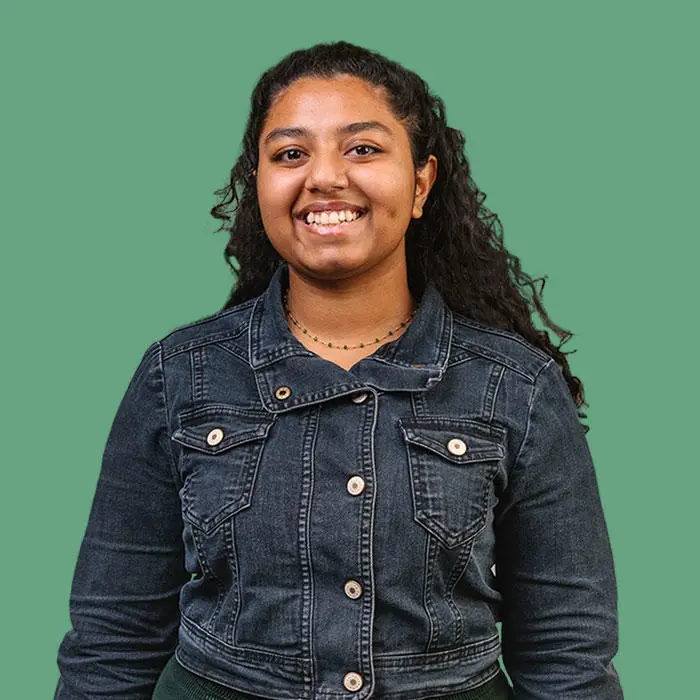 smiling woman in front of a light green background