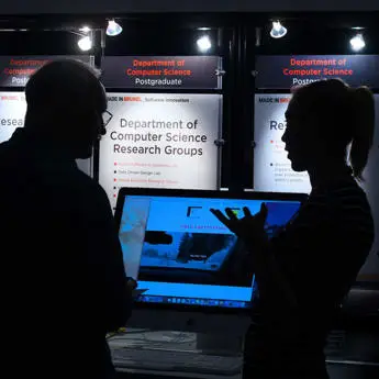 Research student discussing her final year project with industry representative