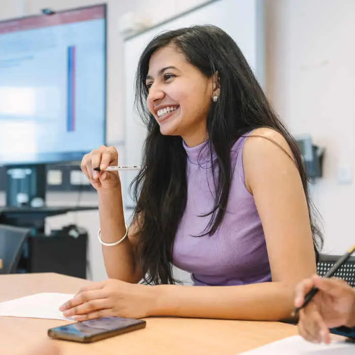 smiling student at a conference table