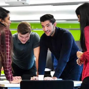 mixed-group-of-students-around-a-table-in-discussion