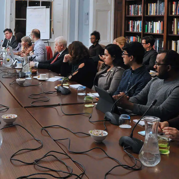Group of student sitting at a long dark brown wooden table