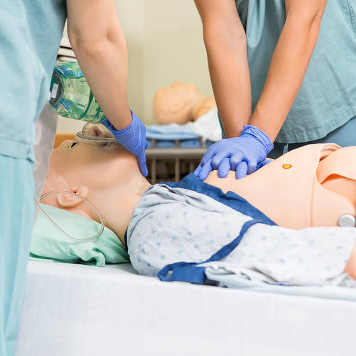 student practicing CPR on medical mannequin