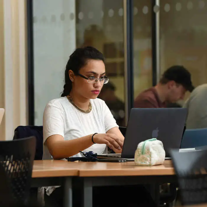 student typing on a laptop