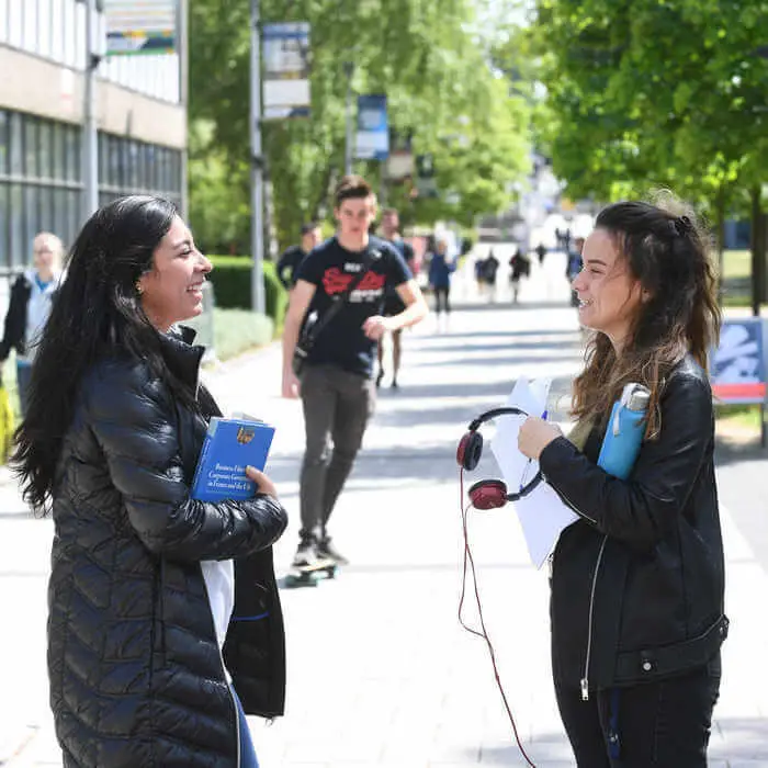 female students chatting on campus concourse